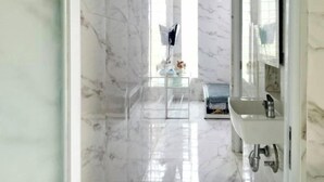 A bathroom with a marble floor, a sink, and a mirror. - TwoSpaces Living at Arfina Residence Syariah, Lamongan (Paciran)