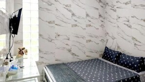 A room with a bed, a glass table, and a window. - TwoSpaces Living at Arfina Residence Syariah, Lamongan (Paciran)
