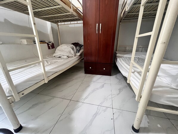A dormitory room with bunk beds, a wooden wardrobe, and a tiled floor. - An Nam Corner- Hostel (Ho Chi Minh City)