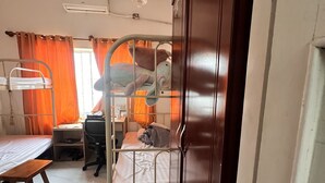A dormitory room with bunk beds, a desk, a chair, and a wardrobe. - An Nam Corner- Hostel (Ho Chi Minh City)
