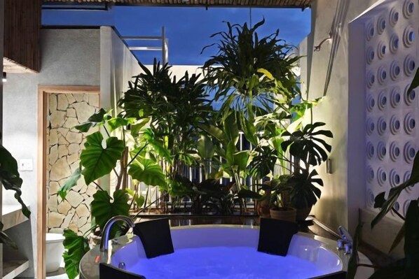 A hot tub surrounded by plants in a modern outdoor setting. - GomiHouse-Cozy-4BRs-5 'to Lotte Mart- jacuzzi pool (Da Nang)