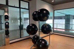 A room with a glass wall, a metal stand holding black spherical objects, and a wooden floor. - 2&3BR Family Suite Nr Sunway Velocity & LRT Maluri (Kuala Lumpur)