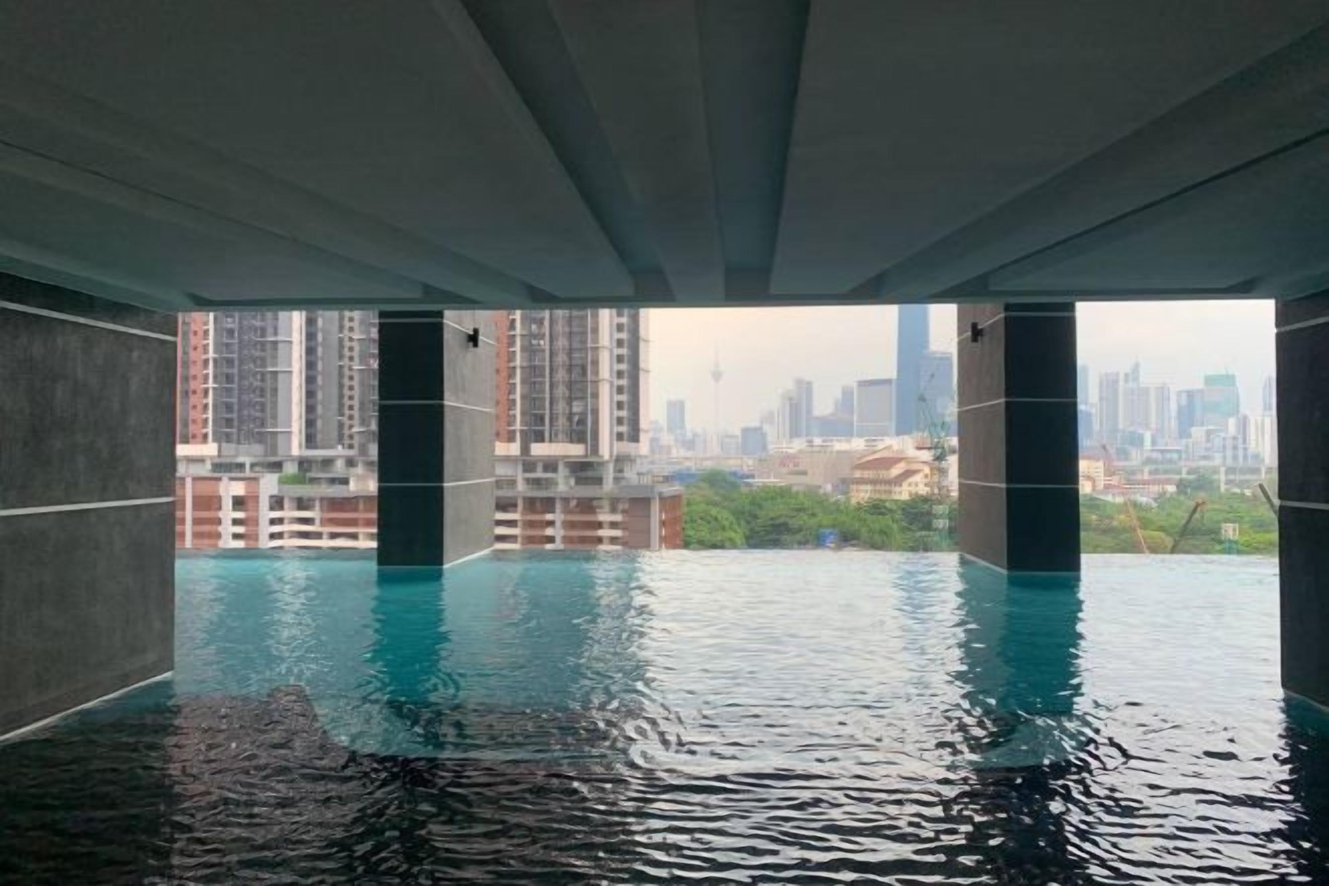 Une piscine intérieure offrant une vue sur le paysage urbain à travers une structure en béton.