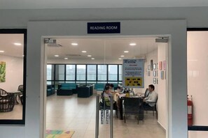 A reading room with a sign, seating area, and a fire extinguisher. - 2&3BR Family Suite Nr Sunway Velocity & LRT Maluri (Kuala Lumpur)