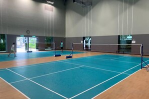 An indoor sports hall with a blue floor, a net, and a door leading outside. - 2&3BR Family Suite Nr Sunway Velocity & LRT Maluri (Kuala Lumpur)