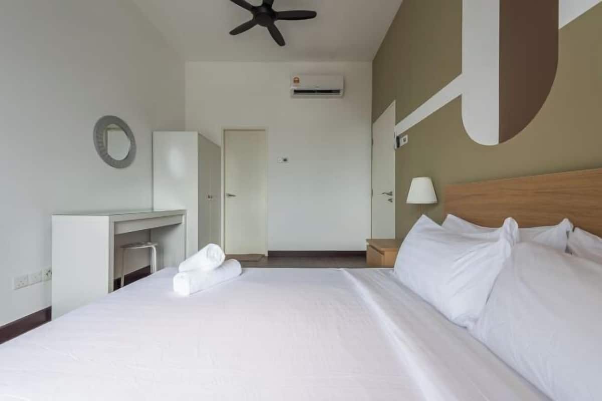 A hotel room with a bed, a desk, a chair, a nightstand, a lamp, an air conditioning unit, and a ceiling fan.
