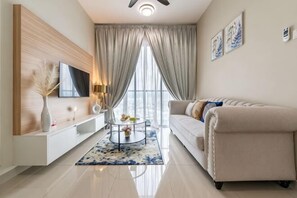 A modern living room with a sofa, TV, and a coffee table. - 2&3BR Family Suite Nr Sunway Velocity & LRT Maluri (Kuala Lumpur)