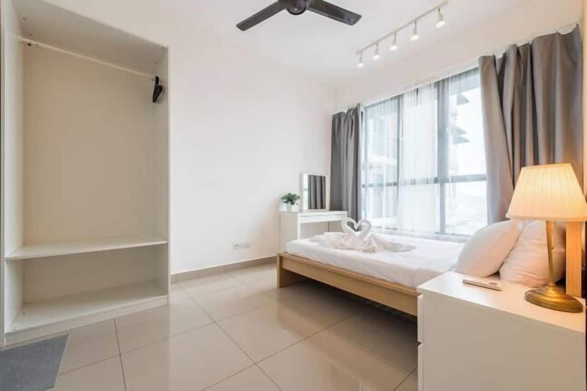 A bedroom with a bed, bedside table, lamp, and a wardrobe.