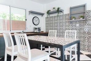 Un comedor con una mesa, sillas, un reloj y azulejos decorados.