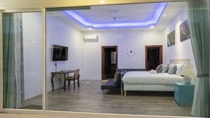 A modern bedroom with a bed, bedside table, and a television on the wall.