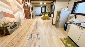 Una cocina con encimera de madera, taburetes de bar, un refrigerador y una ventana.