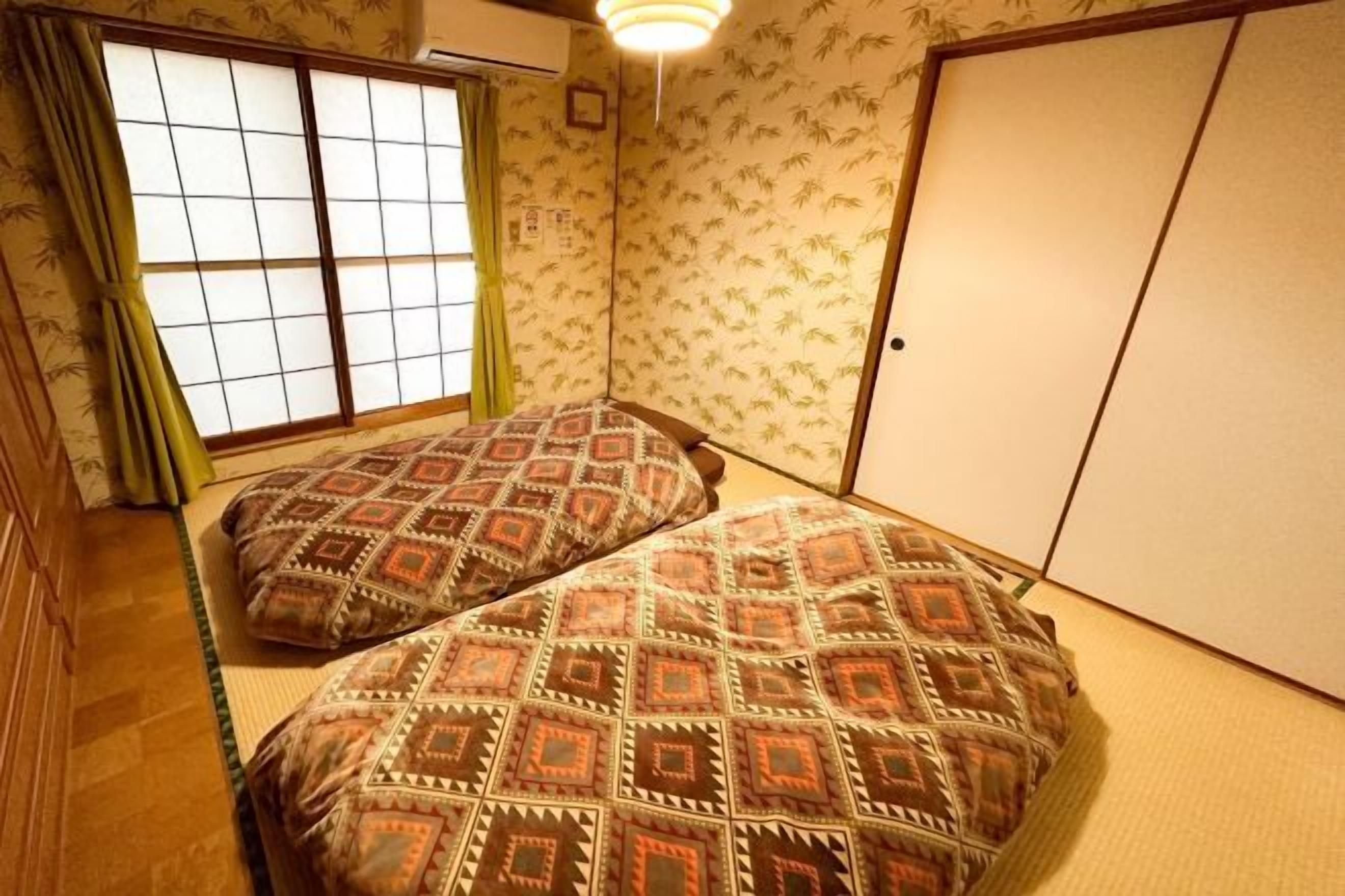 Ein traditioneller japanischer Raum mit Tatami-Bodenbelag, einem Shoji-Fenster und einer Schiebetür.