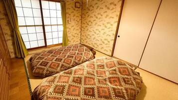 Ein traditioneller japanischer Raum mit Tatami-Bodenbelag, einem Shoji-Fenster und einer Schiebetür.