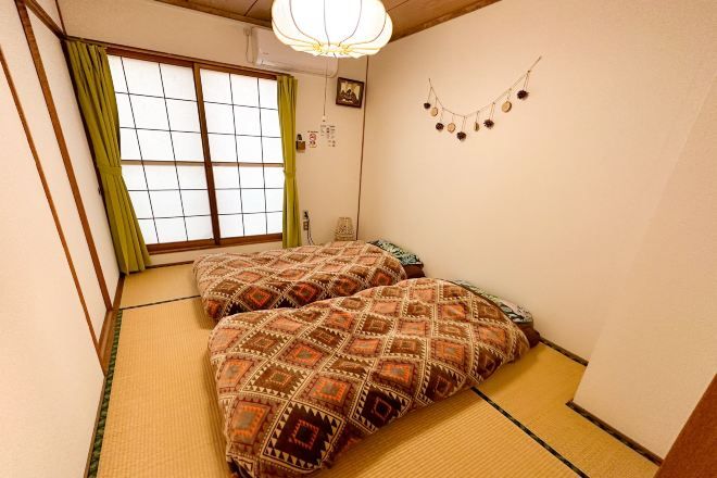 Ein traditioneller japanischer Raum mit Tatami-Bodenbelag, Shoji-Schirm und Futon.