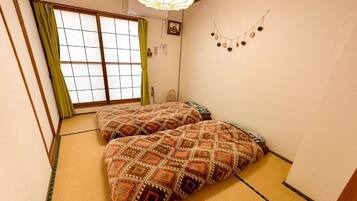 Ein traditioneller japanischer Raum mit Tatami-Bodenbelag, Shoji-Schirm und Futon.