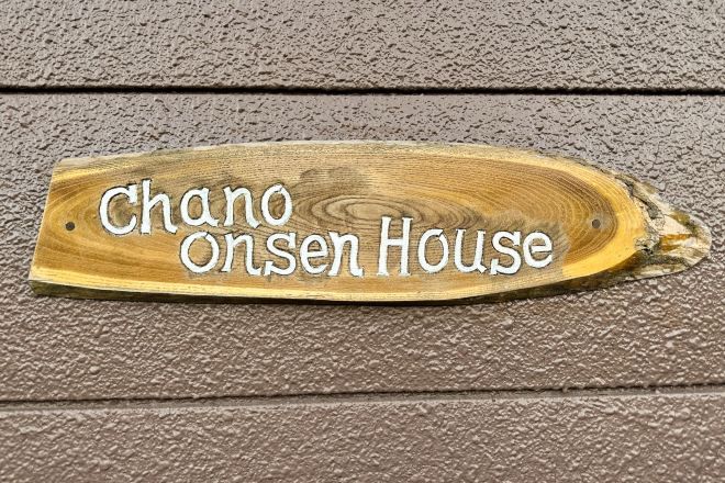 A wooden sign with the text "Chano Onsen House".