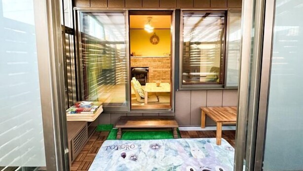 Ein gemütlicher Raum mit einer kleinen Sitzecke, einem sichtbaren Kamin und einem Fenster mit Blick.