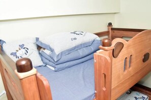 A wooden bed with a headboard, pillows, and a blanket. - TreehouseRiddle (Pasig)