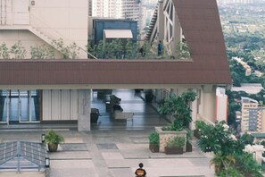 A modern building with a flat roof, a staircase, and a small outdoor area with plants. - TreehouseRiddle (Pasig)