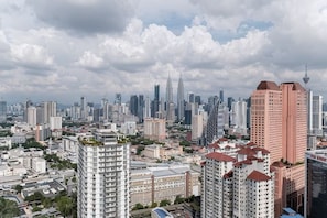 A cityscape with high-rise buildings, including a distinctive tower with a pointed top. - TR Residence BY FEEL HOME (Kuala Lumpur)