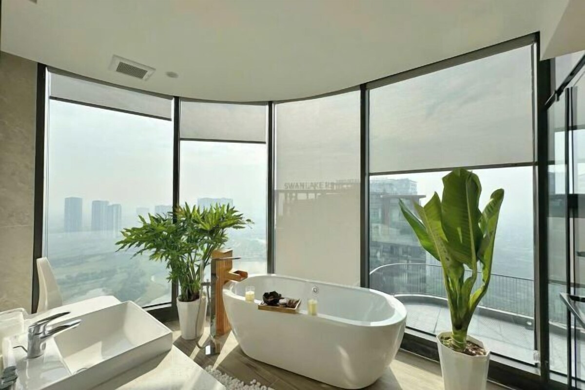 Une salle de bain moderne avec une baignoire sur pieds, une grande fenêtre et une vue sur la ville.