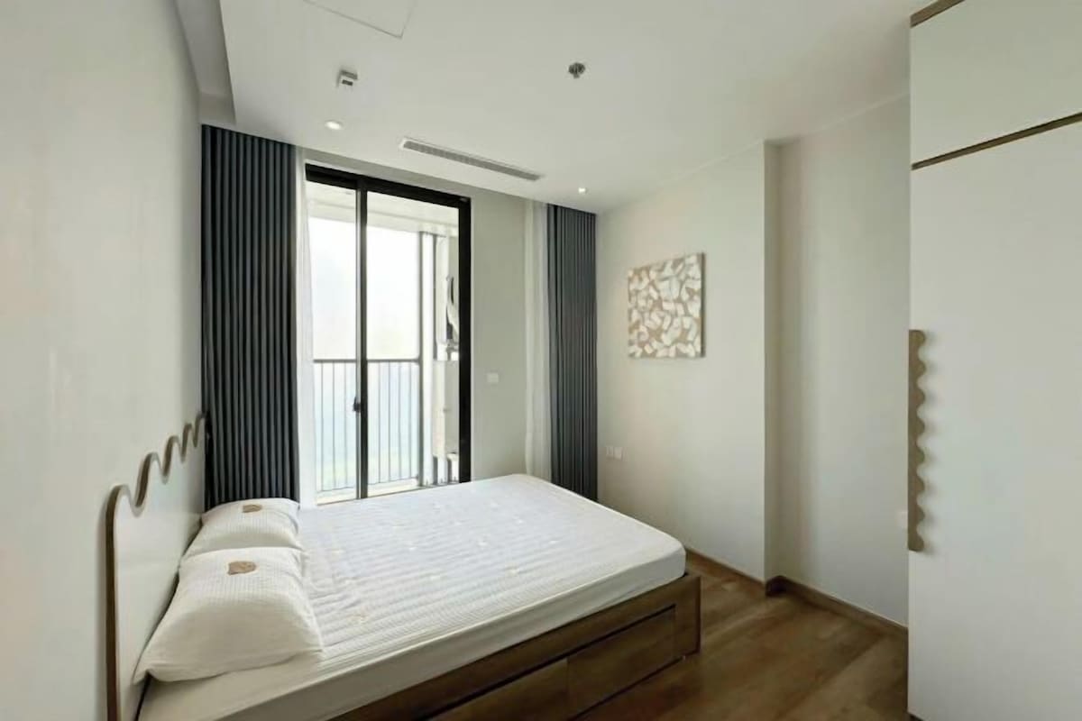 Un dormitorio moderno con cama, una puerta corredera y una obra de arte colgada en la pared.