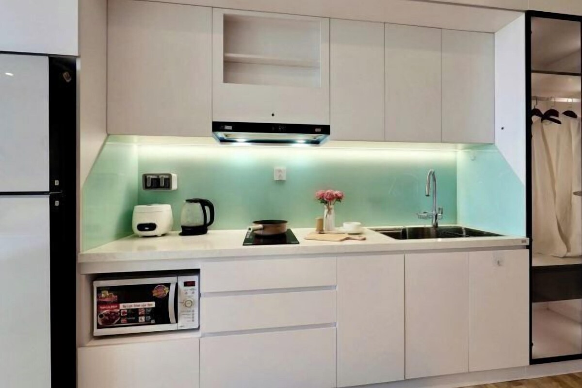 A modern kitchen with a built-in microwave, a coffee maker, and a sink.