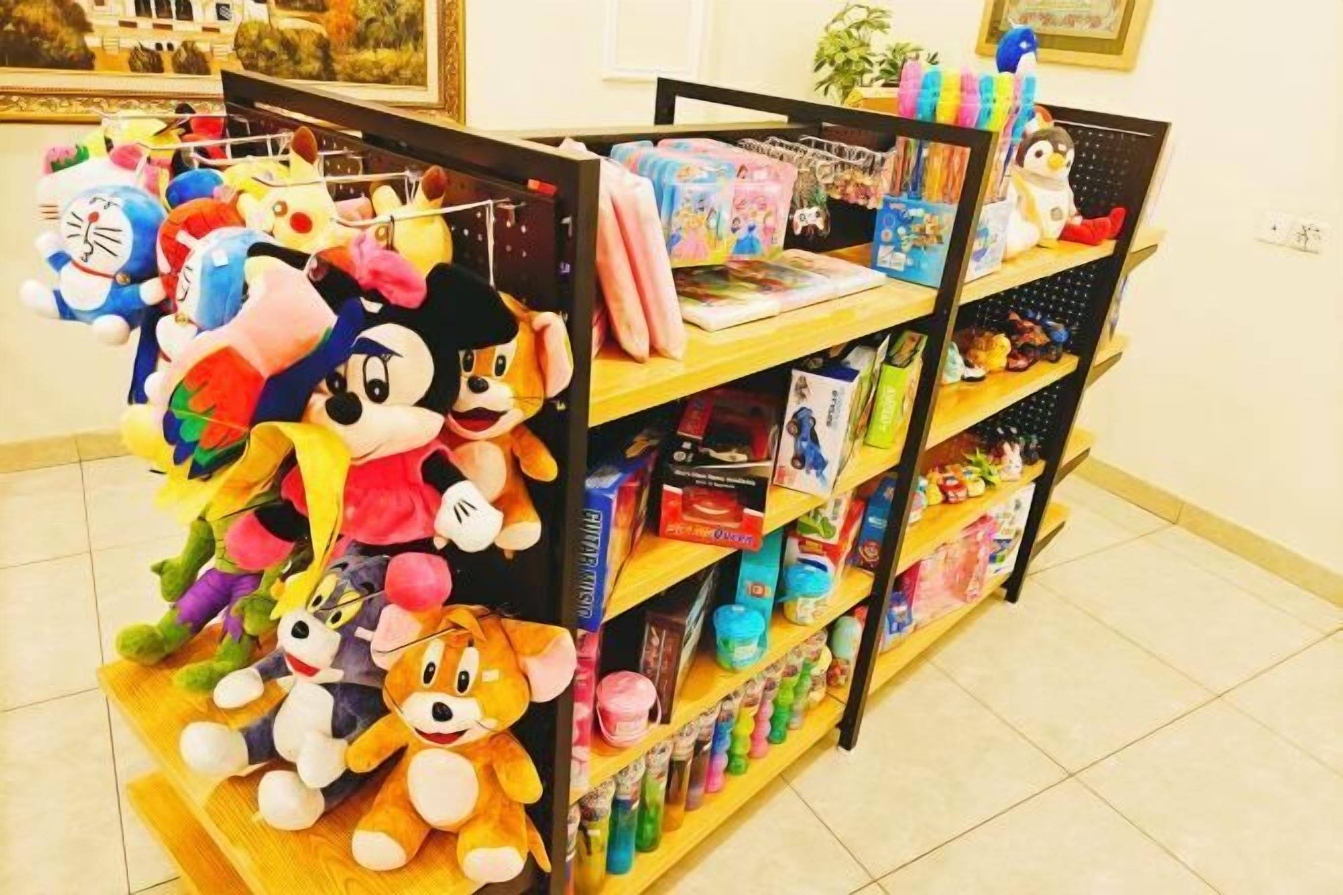 A display of plush toys and children's books on shelves.