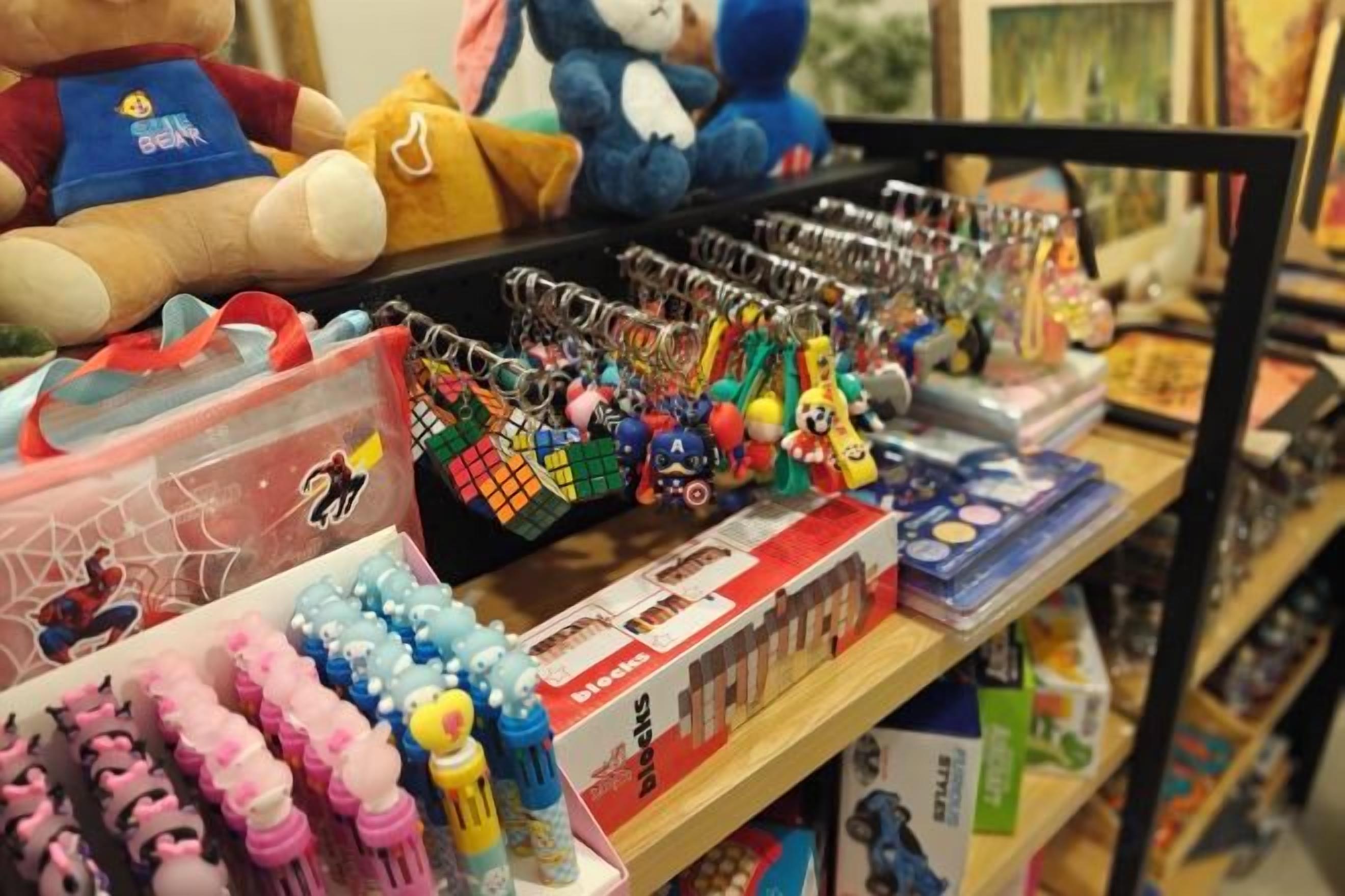 A shelf with various toys and keychains, including a bear and a blue character.
