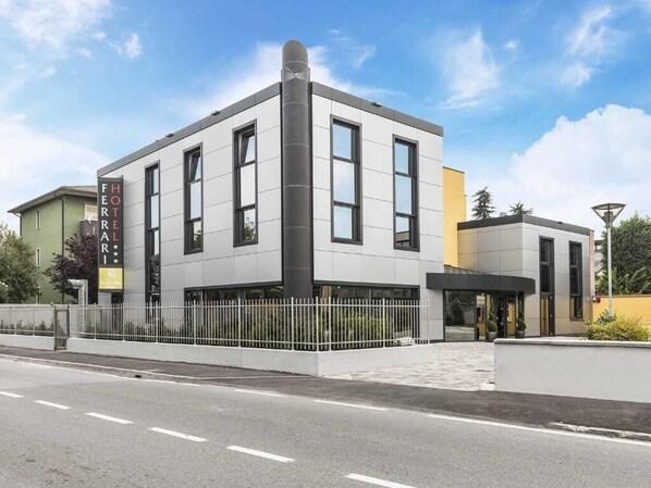 A modern hotel building with a flat facade, large windows, and a prominent entrance. - hotel ferrari milano (Carugate)