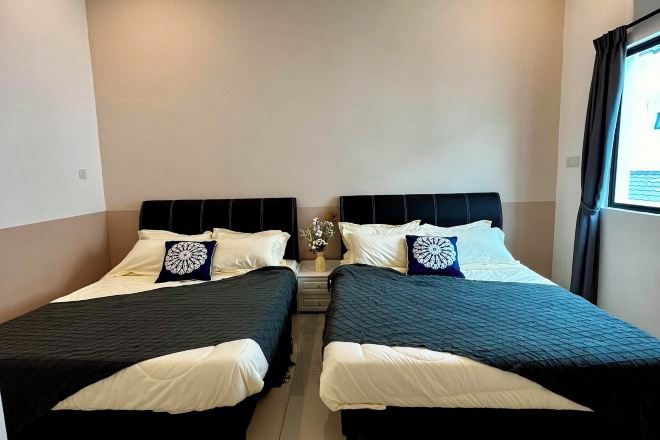 Ein Doppelzimmer mit zwei Betten, jeweils mit Kopfteil, weißer Bettwäsche und dekorativen Kissen.