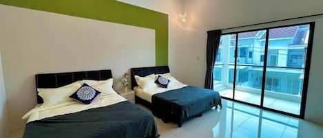 A modern hotel room with two beds, a large window, and a green accent wall.