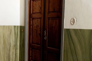 A wooden door with a keyhole and a wall with a light switch. - Modern apartments in the heart of Florence (Florence)
