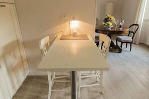 A dining area with a table, chairs, a lamp, and a vase with flowers. - Modern apartments in the heart of Florence (Florence)