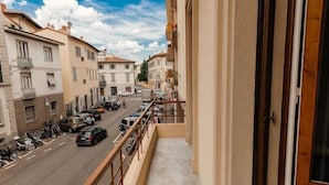 A balcony with a view of a street lined with parked cars and buildings. - Modern apartments in the heart of Florence (Florence)