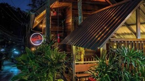 Un edificio in legno con tetto spiovente e insegna al neon.