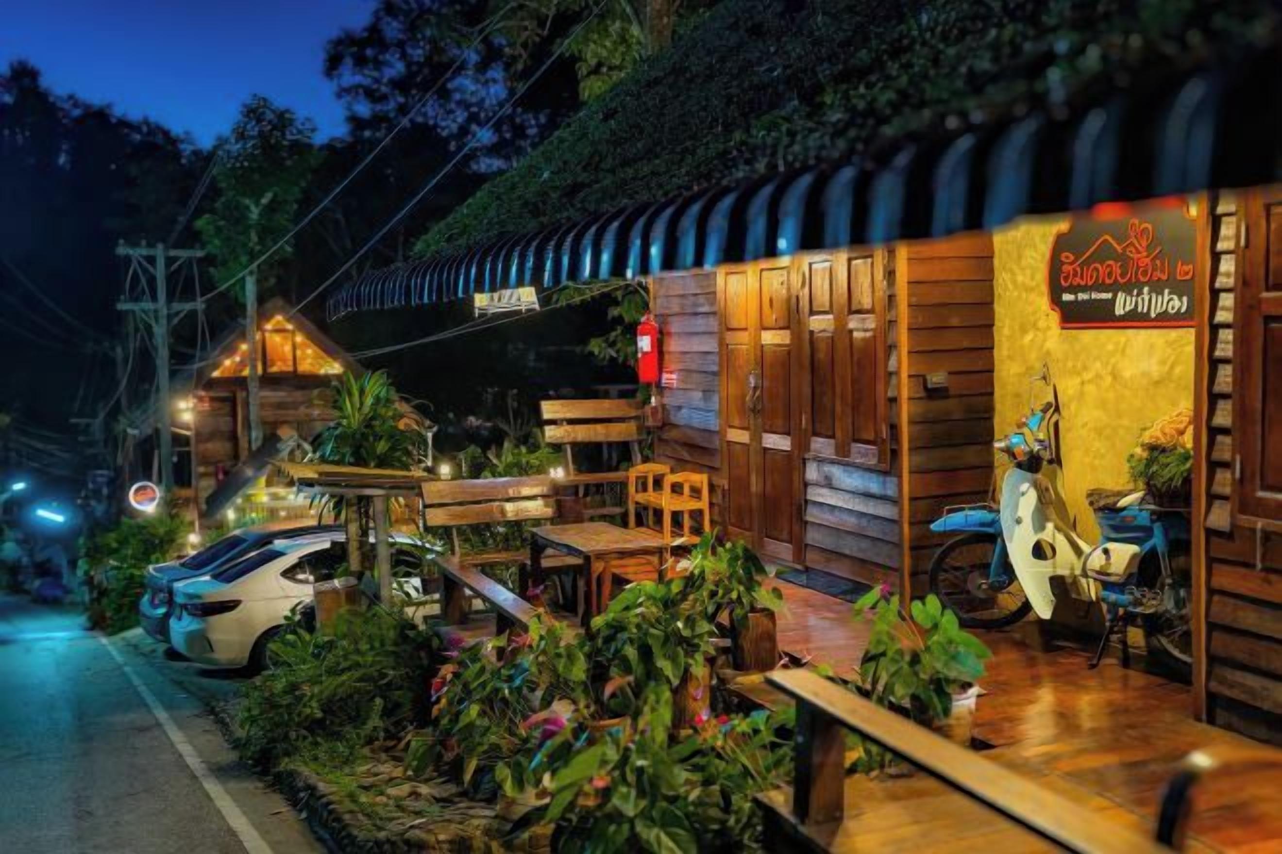 Un edificio de madera con un letrero que dice 'Drinks' y una motocicleta estacionada afuera.