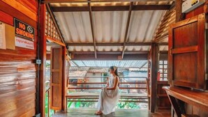 Arredamento in legno con un cartello ‘No Smoking’, una persona con un abito bianco e vista attraverso una porta aperta.