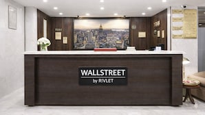 Una recepción con un fondo de paisaje urbano, con la leyenda "WALLSTREET by RIVLET".