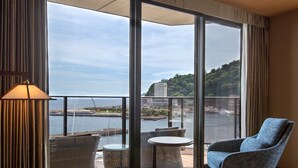 Un balcone con mobili in vimini, un tavolino rotondo e una poltrona blu.