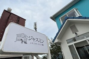 Une enseigne portant le nom « Jasmine » et un bâtiment avec un toit bleu.