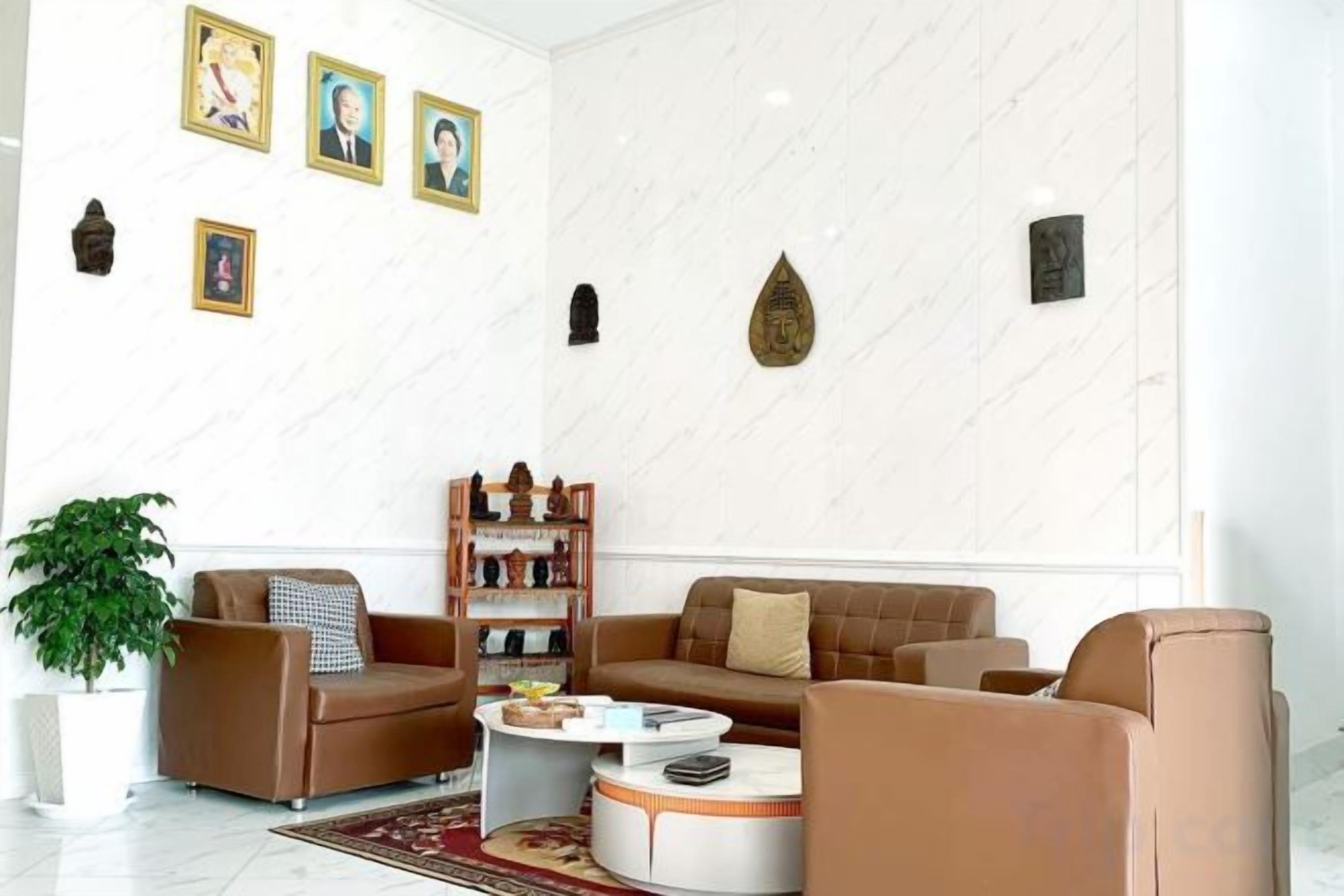 A modern living room with leather sofas, a coffee table, and a bookshelf.