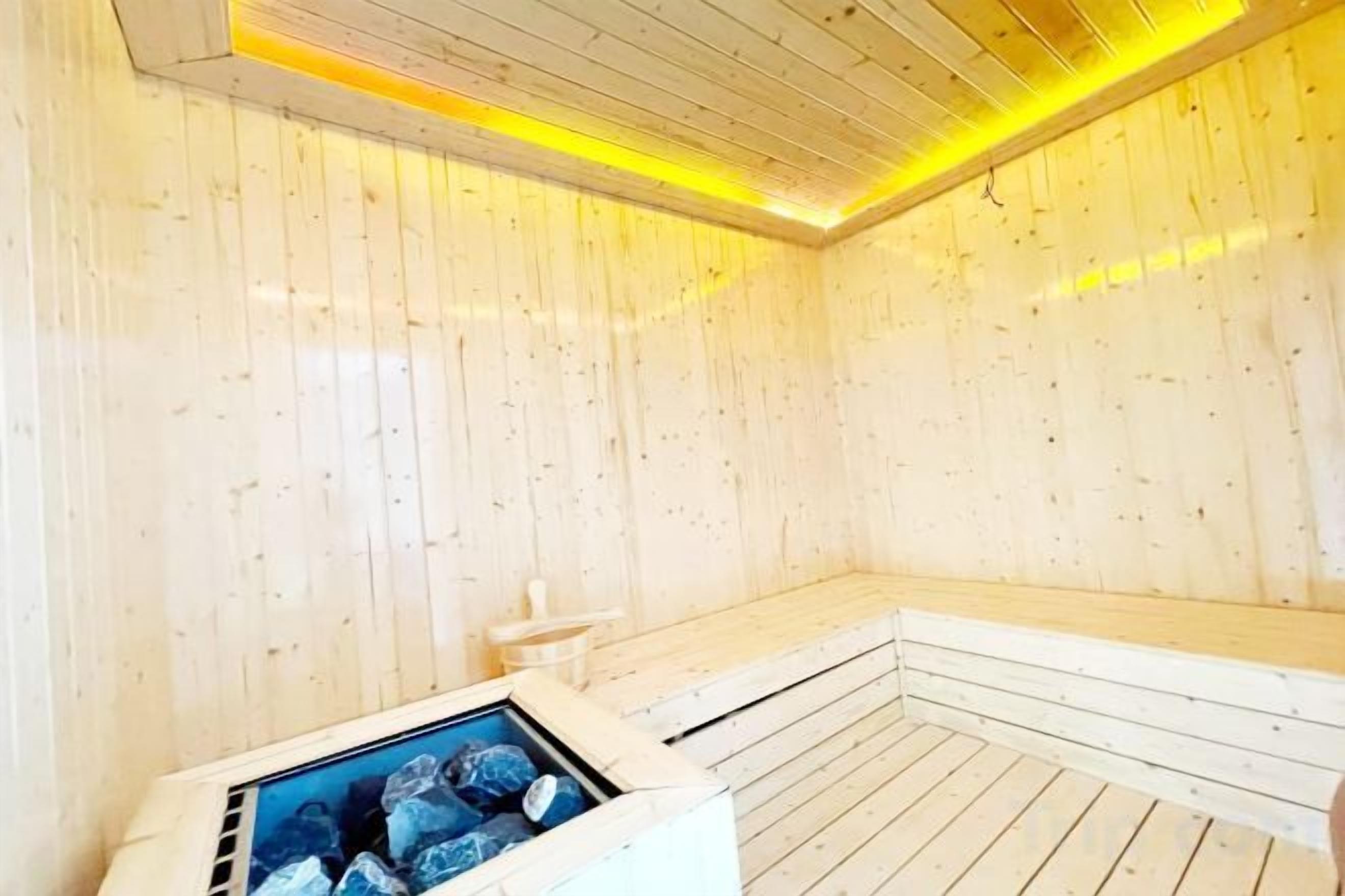 A sauna room with wooden walls and a bench.