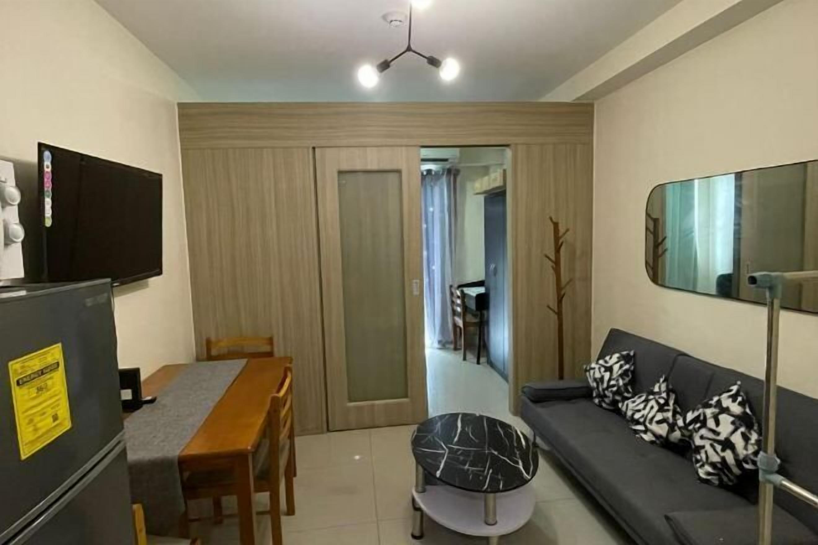 A compact living space with a dining table, sofa, and a small round table.