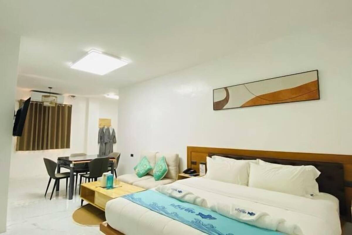 Ein Hotelzimmer mit Bett, Schreibtisch, Stuhl und einem Bild an der Wand.