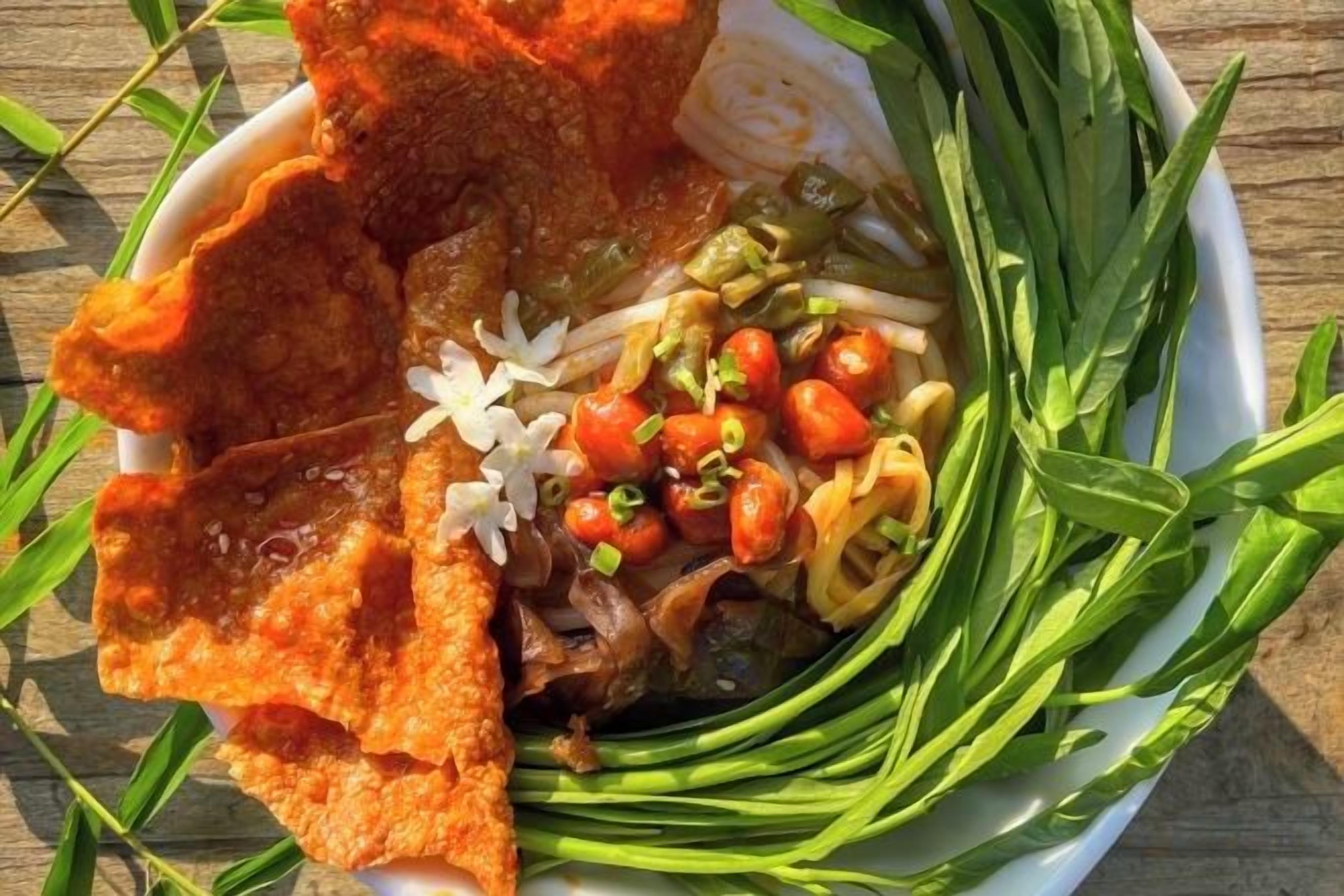 A bowl of food with various ingredients and garnishes.