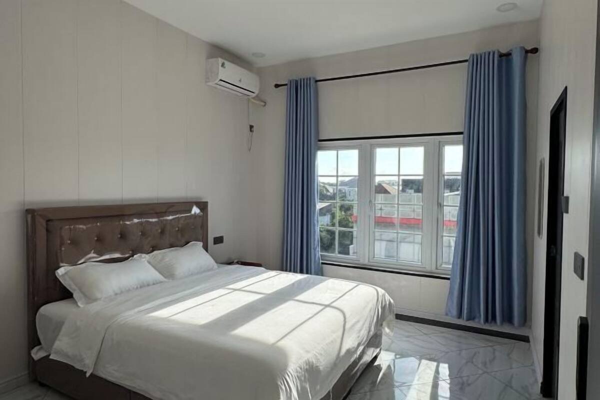 Une chambre à coucher avec un lit, une fenêtre et des rideaux.