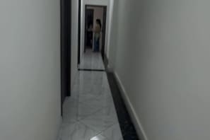 A narrow hallway with a tiled floor and a door at the end. - ZHONG XIANG Hotel (Vientiane)