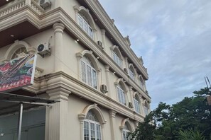 A multi-story building with classical architecture, featuring arched windows and decorative moldings.