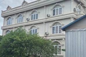 Un edificio a più piani con finestre ad arco e un balcone.
